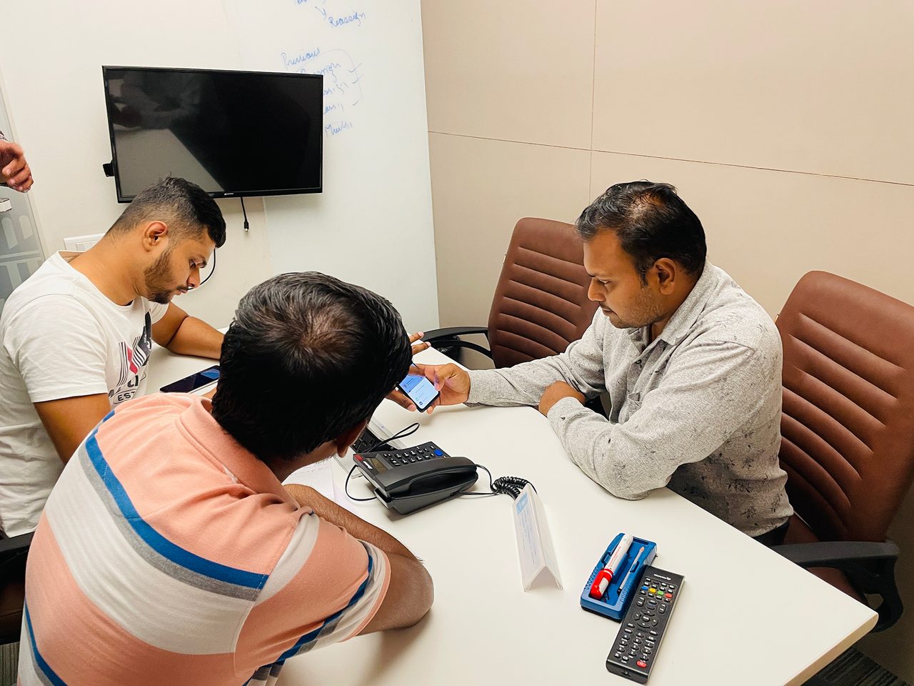 A second participant is handed the app across the table during a moderated test.